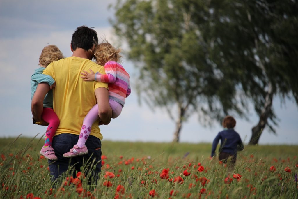 dad-holds-kids-field-of-flowers