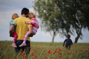 dad-holds-kids-field-of-flowers