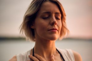 woman meditate hand on heart