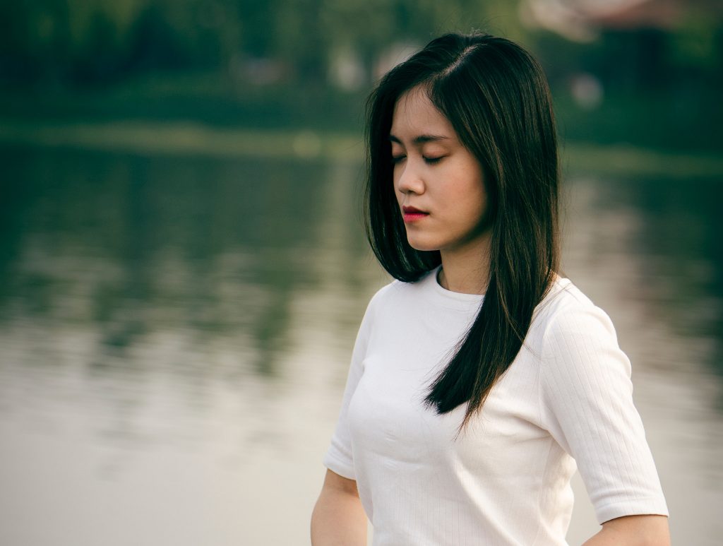 woman meditate still lake